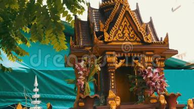 棕色的佛教小祭坛，用花和各种雕像装饰在花园里祈祷
